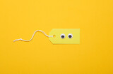 Creative layout, sale, shopping concept. Price tag with eyes on yellow background