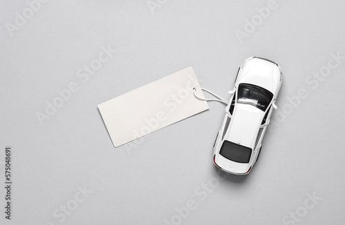Fotografía Toy car model with price tag on a gray background. Top view