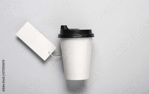 Coffee cardboard cup with price tag on gray background