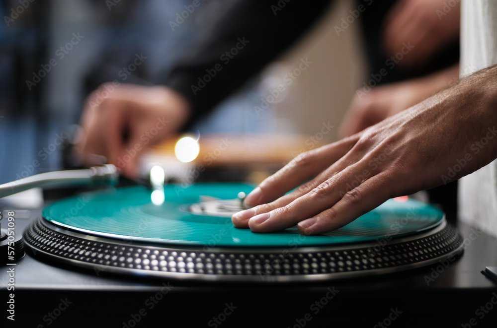 DJ plays music with vinyls and turntables. Hand of hip hop disc jockey mixing records on stage