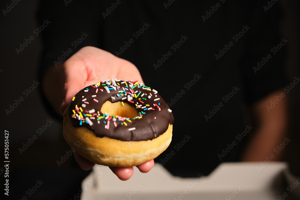 donut with chocolate in a woman's hand