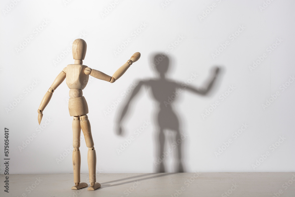 The shadow of a wooden mannequin on the wall. The shadow of a wooden mannequin on the wall.