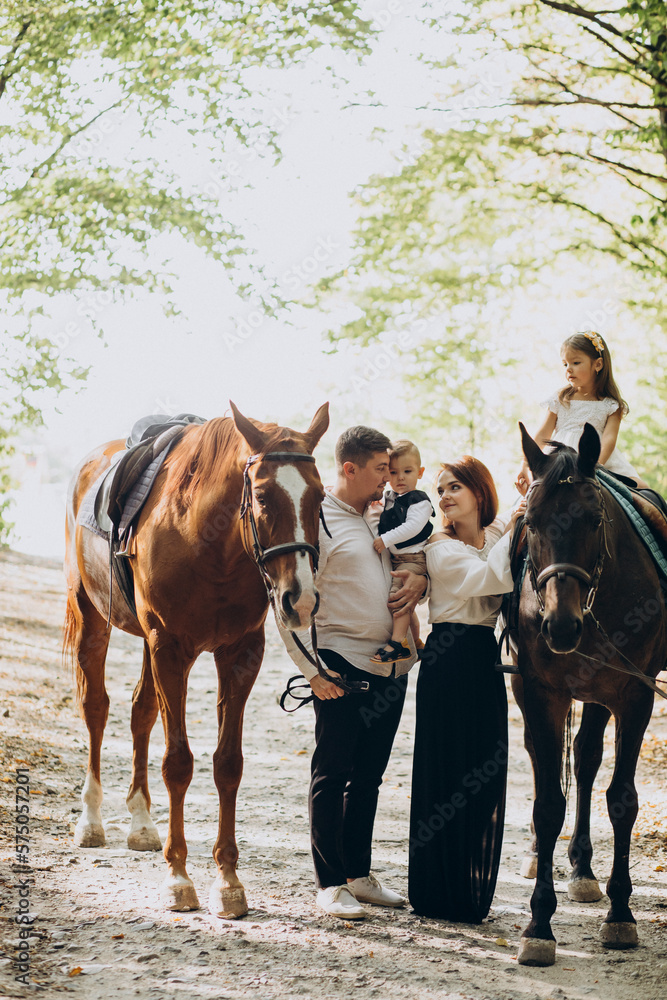 Young family with kids having fun with horse in forest Young family with kids having fun with horse in forest