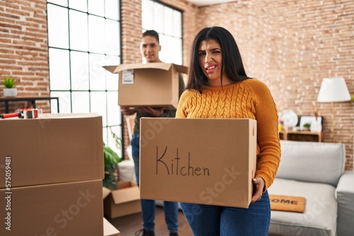 Young couple moving to a new home with cardboard boxes clueless and confused expression. doubt concept. © Krakenimages.com