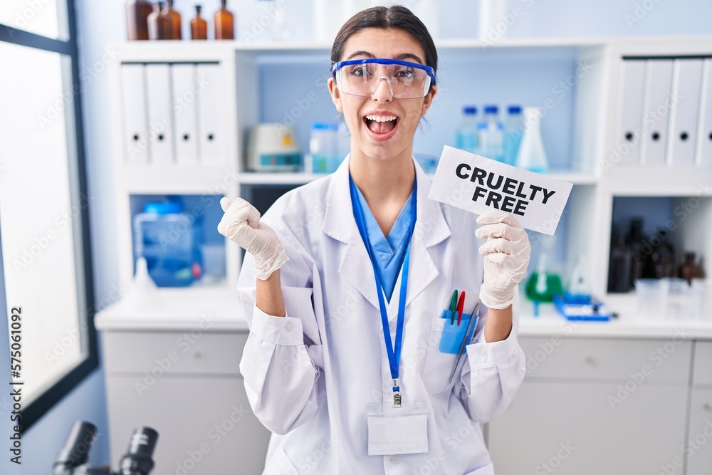 Young beautiful woman working on cruelty free laboratory screaming proud, celebrating victory and success very excited with raised arms Young beautiful woman working on cruelty free laboratory screaming proud, celebrating victory and success very excited with raised arms