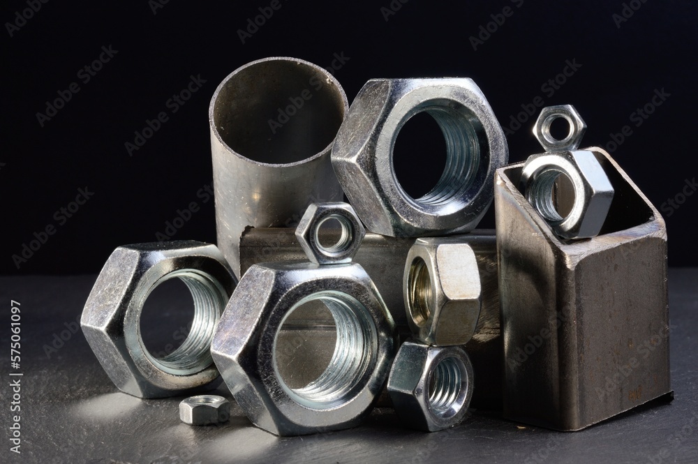 composition of nuts bolts and scraps of metal laid out on a dark background. composition of nuts bolts and scraps of metal laid out on a dark background.