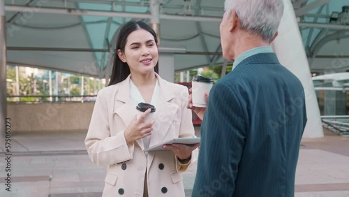 Asian senior mature middle aged businessman and young businesswoman having a discussion and coffee in modern city