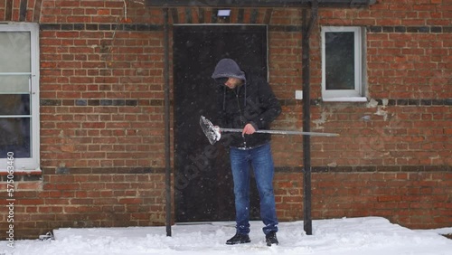 Wallpaper Mural Man looking on broken equipment for snow removing. Cloudy cold day during snowfall. Cleaning territory in winter. Snowstorm in winter season. Backyard care in blizzard Torontodigital.ca