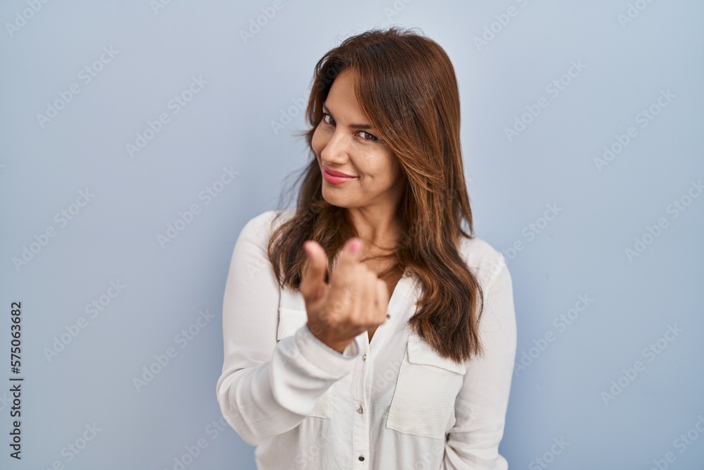 Hispanic woman standing over isolated background beckoning come here gesture with hand inviting welcoming happy and smiling Hispanic woman standing over isolated background beckoning come here gesture with hand inviting welcoming happy and smiling