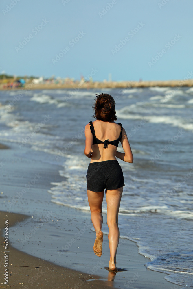 girl jogging running on the seashore in summer girl jogging running on the seashore in summer