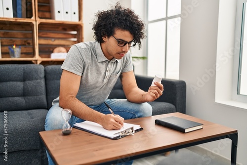 Young hispanic man psychologist prescribe pills at psychology center