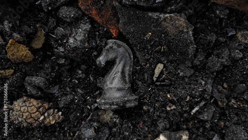 A black horse chess piece is among the rubble