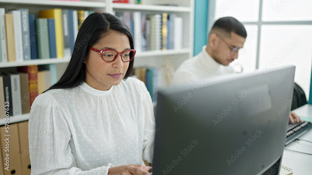Man and woman students using computer studying at university classroom Man and woman students using computer studying at university classroom