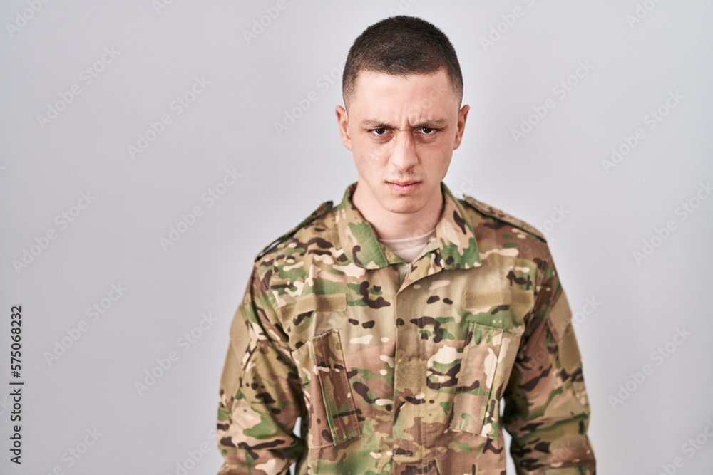 Young man wearing camouflage army uniform skeptic and nervous, frowning upset because of problem. negative person.