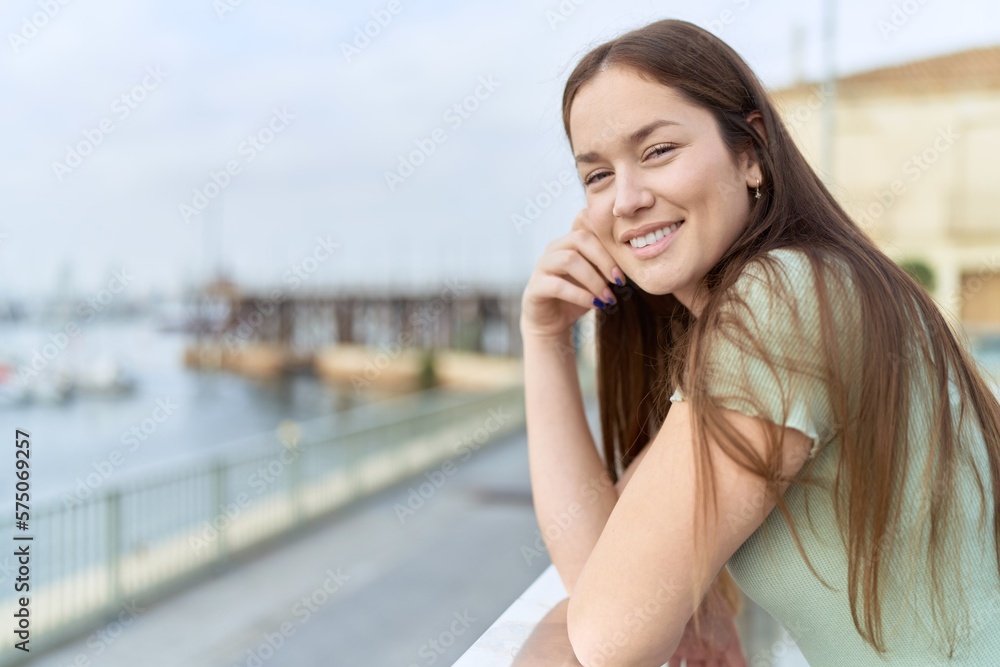 Young beautiful woman smiling confident standing at seaside Young beautiful woman smiling confident standing at seaside