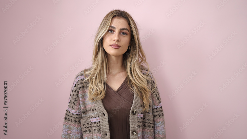 Obraz premium Young blonde woman looking to the camera with relaxed expression over isolated pink background