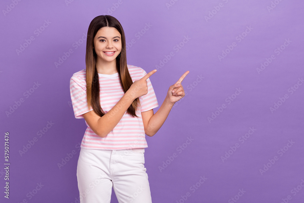 Photo of pretty sweet young lady wear striped pink white t-shirt pointing two fingers empty space isolated violet color background Photo of pretty sweet young lady wear striped pink white t-shirt pointing two fingers empty space isolated violet color background