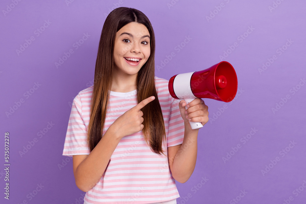 Photo of funky excited lady wear striped white t-shirt pointing finger bullhorn isolated violet color background Photo of funky excited lady wear striped white t-shirt pointing finger bullhorn isolated violet color background