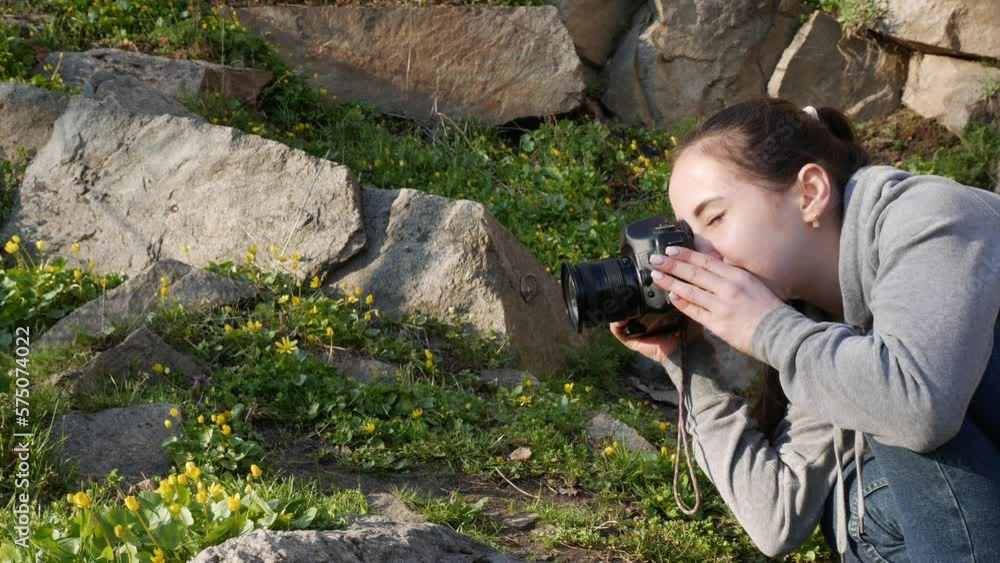 Girl with a professional camera in nature. Holds a camera and takes pictures of nature. Girl with a professional camera in nature. Holds a camera and takes pictures of nature.