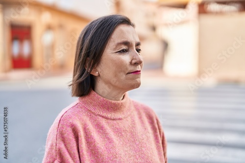 Middle age woman with relaxed expression standing at street