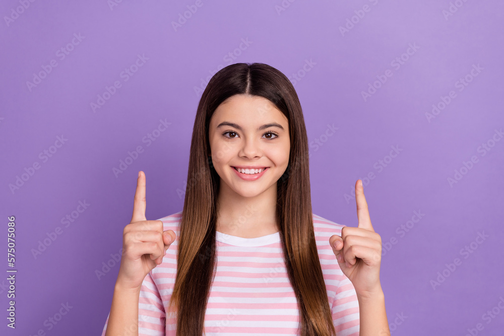 Photo of pretty charming girl dressed striped white pink t-shirt pointing up empty space isolated purple color background Photo of pretty charming girl dressed striped white pink t-shirt pointing up empty space isolated purple color background