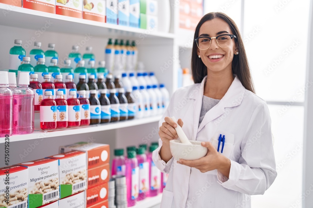 Young beautiful hispanic woman pharmacist smiling confident working at pharmacy
