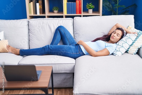 Young beautiful hispanic woman lying on sofa sleeping at home