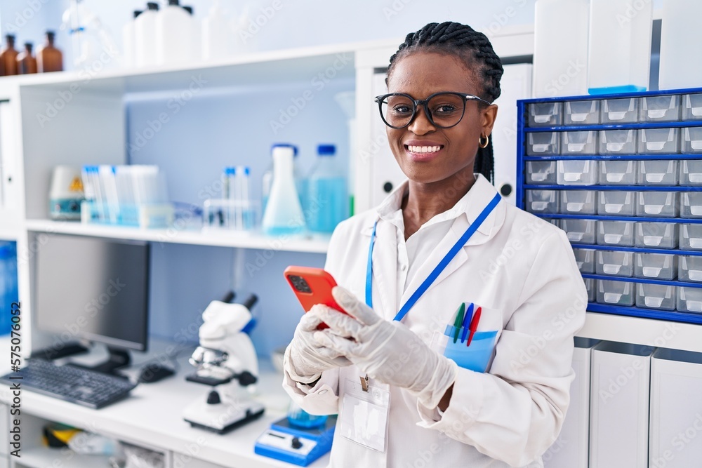 African american woman scientist smiling confident using smartphone at laboratory African american woman scientist smiling confident using smartphone at laboratory