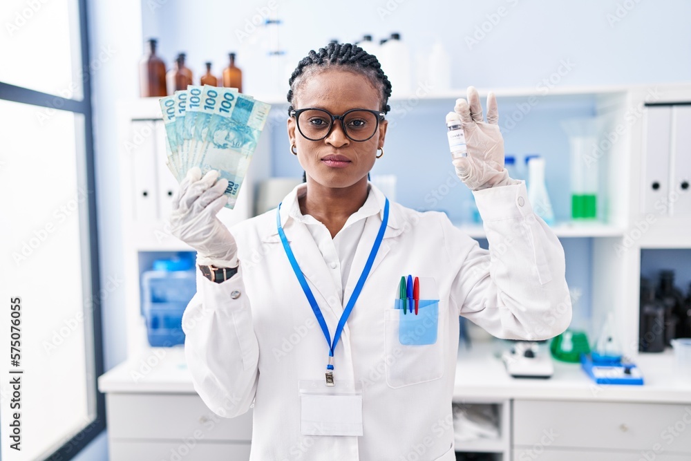 African woman with braids working at scientist laboratory holding money depressed and worry for distress, crying angry and afraid. sad expression. African woman with braids working at scientist laboratory holding money depressed and worry for distress, crying angry and afraid. sad expression.