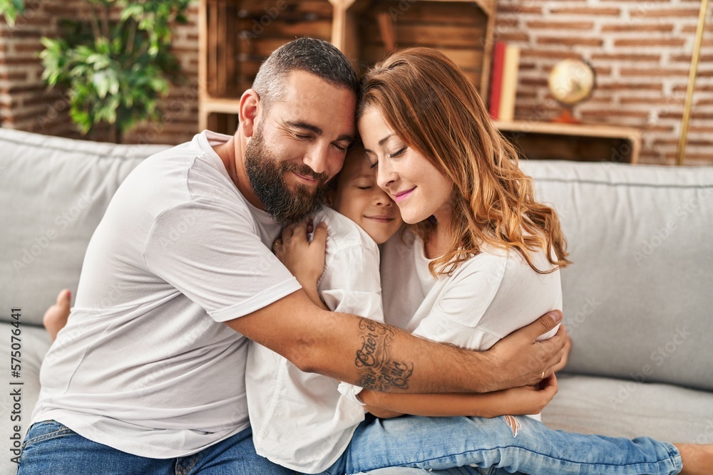 Family hugging each other sitting on sofa at home Family hugging each other sitting on sofa at home