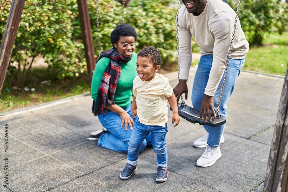 African american family playing on swing at playground African american family playing on swing at playground