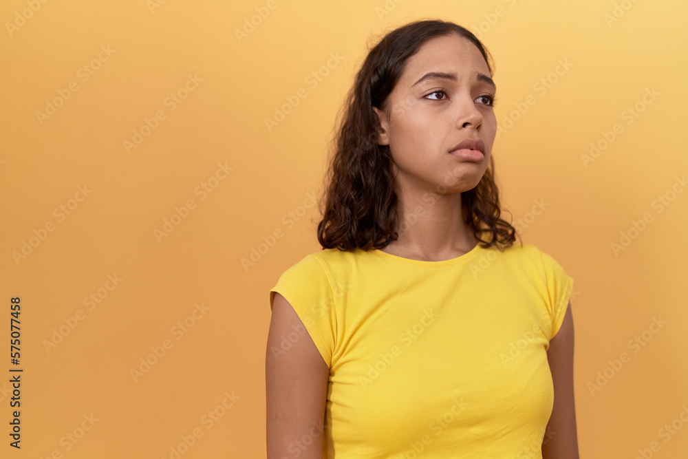 Obraz premium Young african american woman standing with sad expression over isolated yellow background