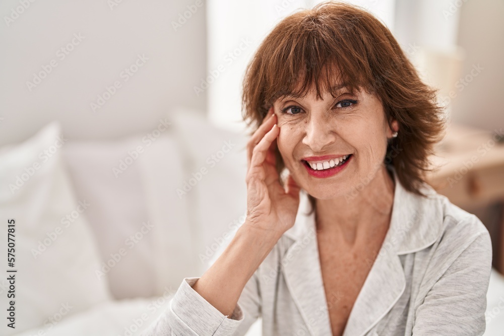 Middle age woman smiling confident sitting on bed at bedroom Middle age woman smiling confident sitting on bed at bedroom