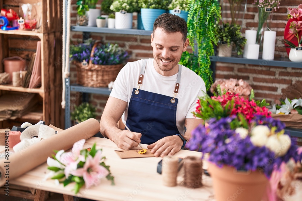 Young hispanic man florist smiling confident writing on envelope letter at florist Young hispanic man florist smiling confident writing on envelope letter at florist