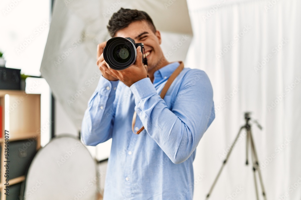 Young hispanic man photographer using professional camera at photography studio Young hispanic man photographer using professional camera at photography studio