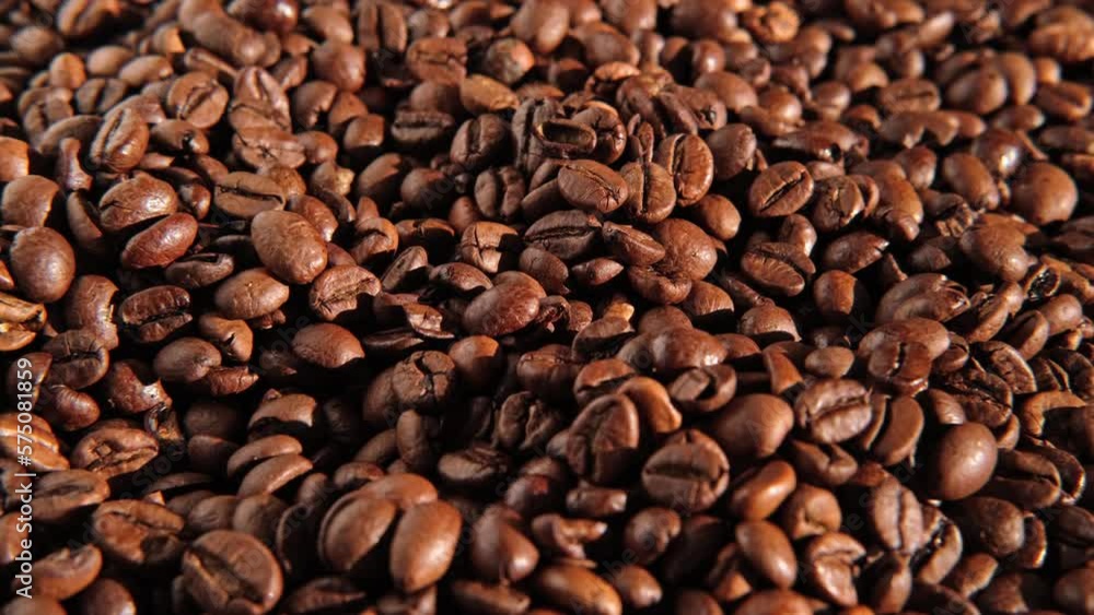Coffee beans background. Texture of coffee beans close up. Dark brown roasted coffee is spinning. Abundance. Concept for coffee product advertising. Selective Focus. Border design with copy space Coffee beans background. Texture of coffee beans close up. Dark brown roasted coffee is spinning. Abundance. Concept for coffee product advertising. Selective Focus. Border design with copy space