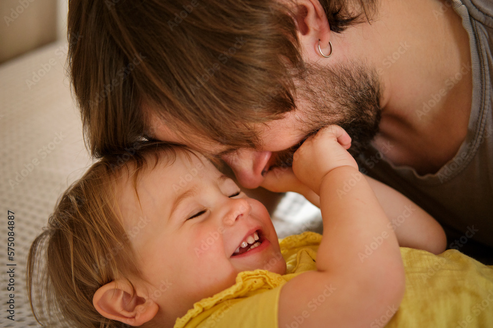 Happy Father with Daughter, Tiny Girl. One Year Baby Smiling, Laughing, Looking up at Daddy. Man Showing Affection to Child. Candid Real Emotion. Beard Dad and Little Kid. Authentic Family Lifestyle. - obrazy, fototapety, plakaty 