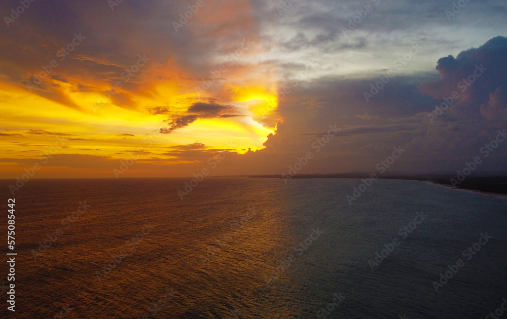 Aerial view of the sunset in an orange sky with clouds. Beautiful background for tourism and advertising. Tropical coast Aerial view of the sunset in an orange sky with clouds. Beautiful background for tourism and advertising. Tropical coast