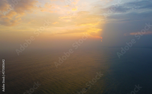 Aerial view of the sunset in an orange sky with clouds. Beautiful background for tourism and advertising. Tropical coast