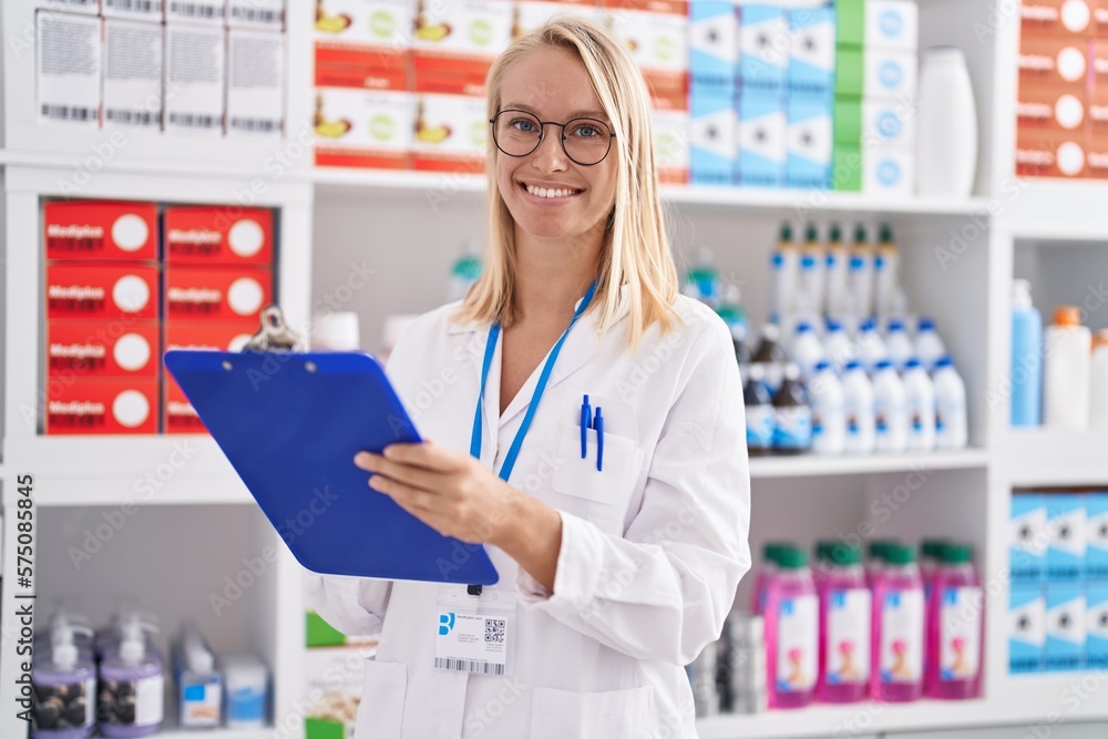 Young blonde woman pharmacist writing on document at pharmacy Young blonde woman pharmacist writing on document at pharmacy
