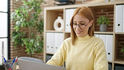 Young blonde woman business worker using laptop working at office