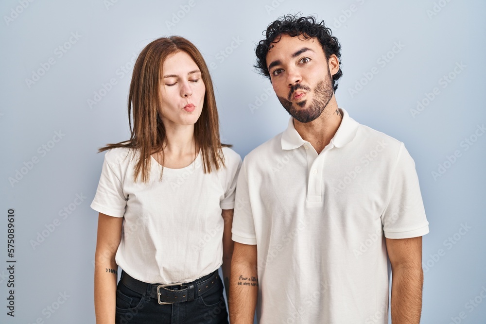 Fototapeta premium Young couple wearing casual clothes standing together making fish face with lips, crazy and comical gesture. funny expression.