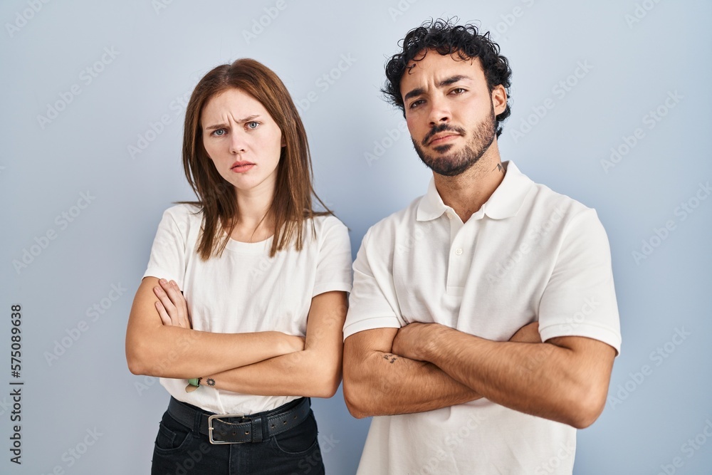 Young couple wearing casual clothes standing together skeptic and nervous, disapproving expression on face with crossed arms. negative person.