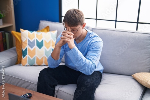 Young caucasian man stressed sitting on sofa at home © Krakenimages.com