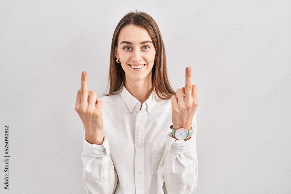 Young caucasian woman standing over isolated background showing middle finger doing fuck you bad expression, provocation and rude attitude. screaming excited Young caucasian woman standing over isolated background showing middle finger doing fuck you bad expression, provocation and rude attitude. screaming excited