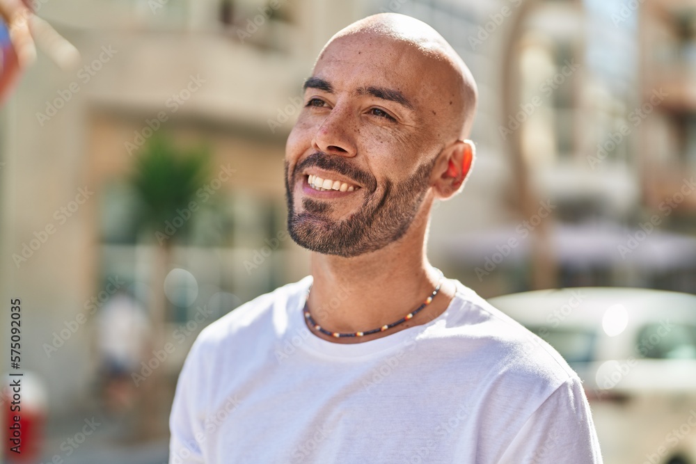 Young bald man smiling confident looking to the side at street Young bald man smiling confident looking to the side at street