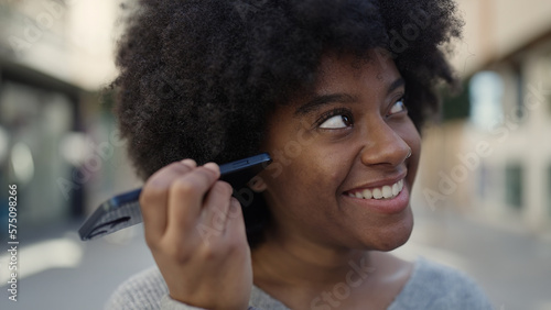 African american woman smiling confident listening audio message by the smartphone at street