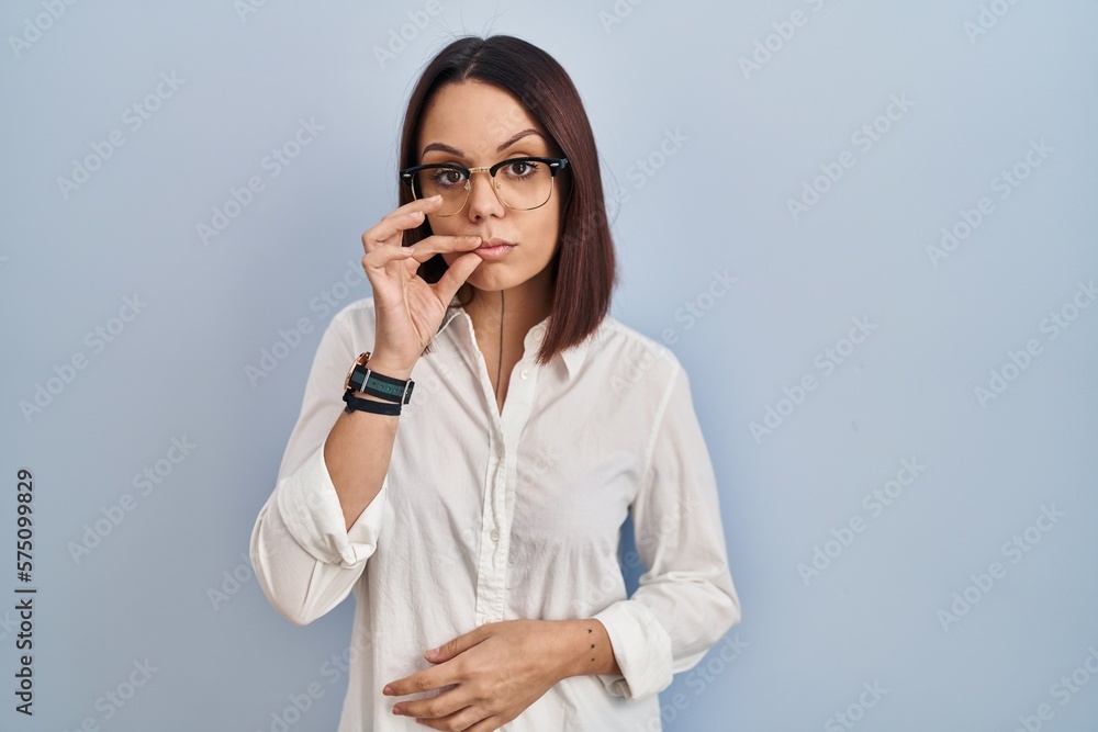 Young hispanic woman standing over white background mouth and lips shut as zip with fingers. secret and silent, taboo talking Young hispanic woman standing over white background mouth and lips shut as zip with fingers. secret and silent, taboo talking
