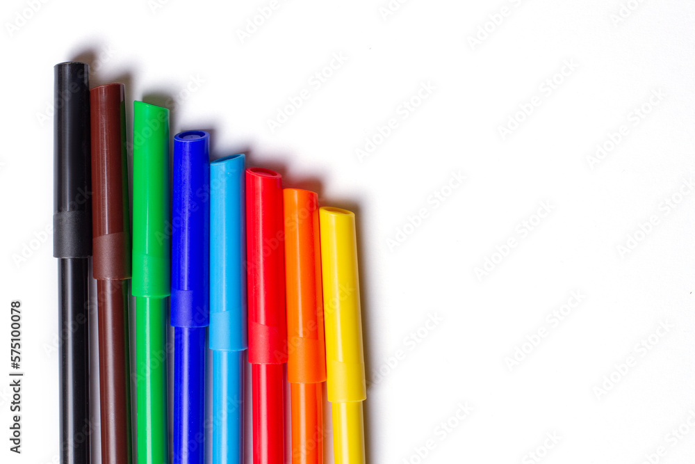 Fototapeta premium Markers of different colors lie in a row. On a white background.