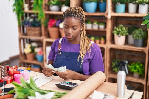 African american woman florist counting dollars at florist